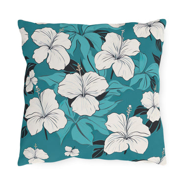 Decorative pillow with white floral design on a teal background